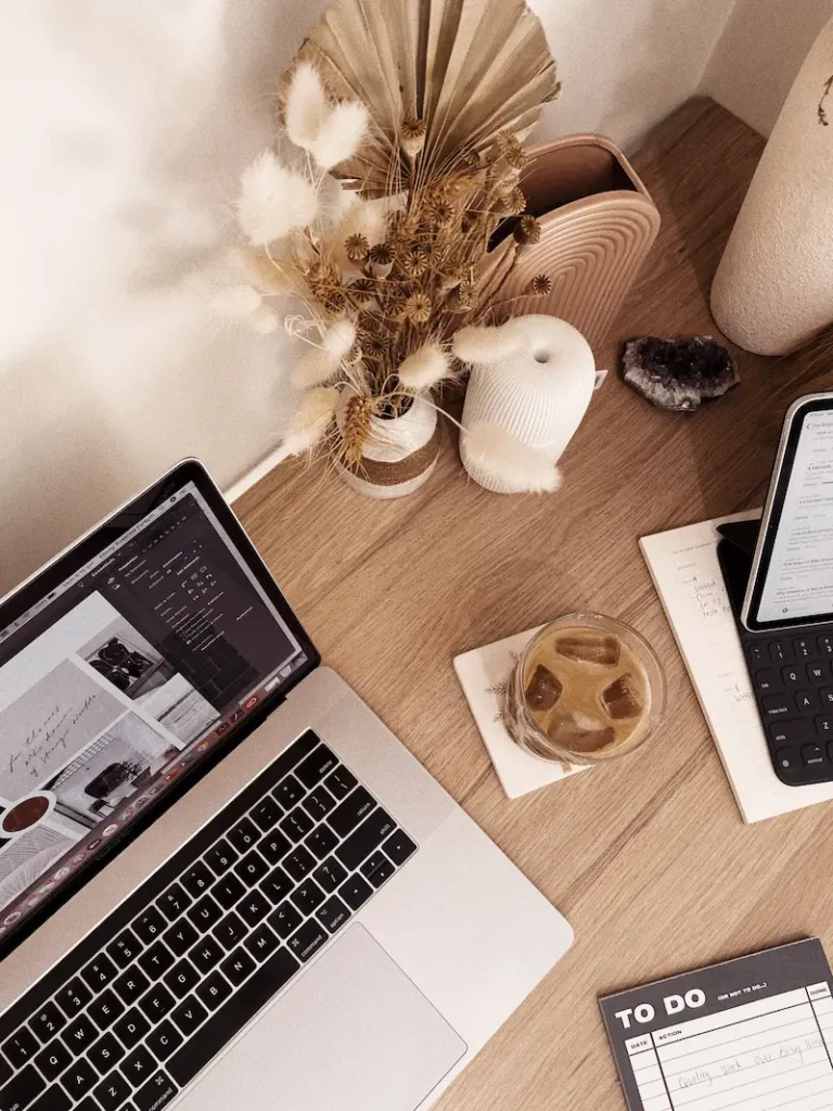 Ordinateur portable sur un bureau en bois avec des fleurs séchées