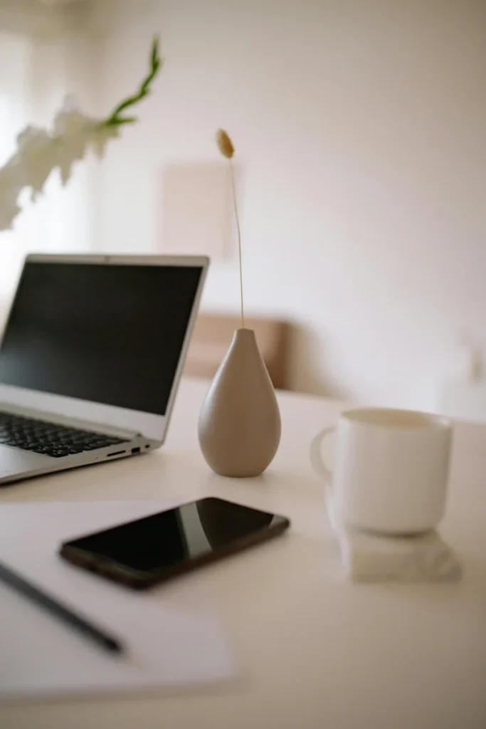 Ordinateur sur un bureau avec café et vase en céramique,
