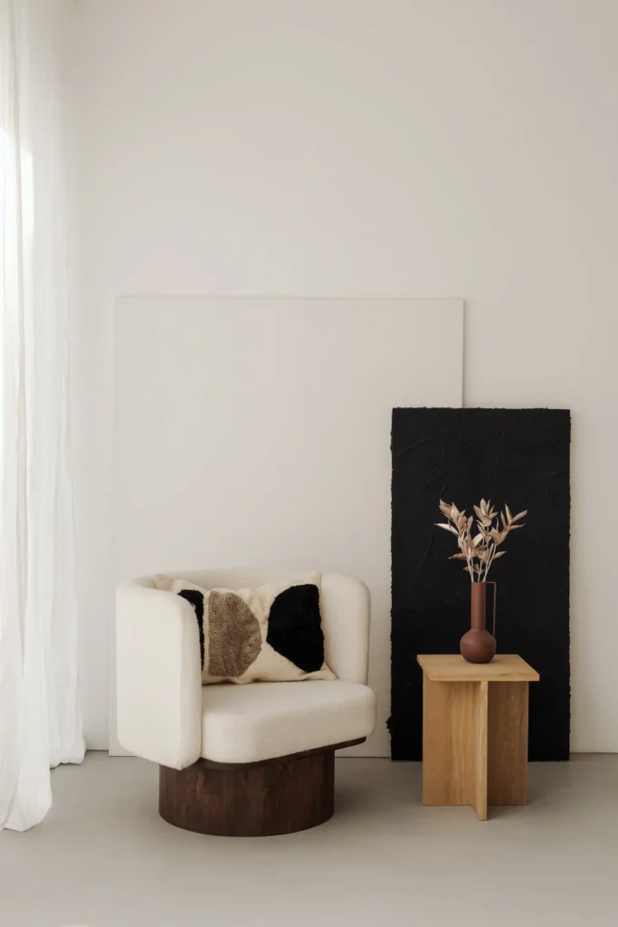 Salon cosy avec un fauteuil blanc et bois et un vase marron