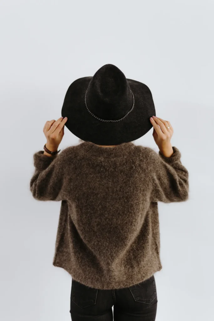 Silhouette d'une femme en pull marron et chapeau noir